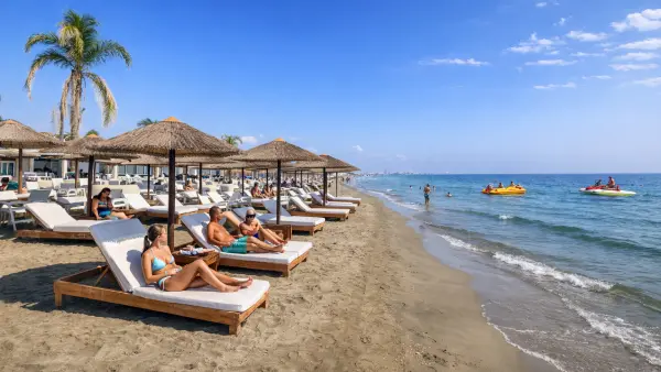 Plaża Lady's Mile w Limassol na Cyprze – ogromna przestrzeń, ciemny wulkaniczny piasek i krystaliczna płytka woda